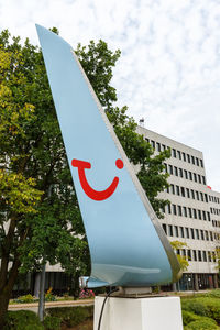 Low angle view of sign board against sky in city