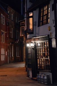 View of alley amidst buildings at night