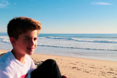 Boy on beach against sky