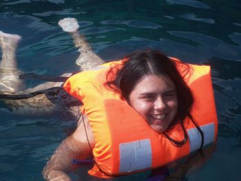 Portrait of a smiling woman swimming in pool