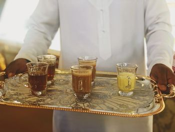 Arabic man holding a tray with drinks - traditional tea and coffee 