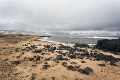 Scenic view of beach against sky during winter