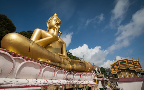 Giant sitting buddha on rang hill temple or wat khao rang with blue sky in phuket, thailand