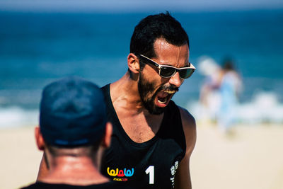 Portrait of man wearing sunglasses at beach