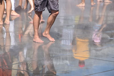 Low section of people standing on wet floor during rainy season