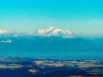 Scenic view of land and mountains against blue sky