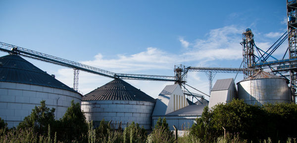 Low angle view of agricultural factory against sky