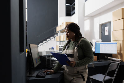 Side view of young man standing in office