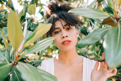 Close-up portrait of teenage girl standing amidst plants