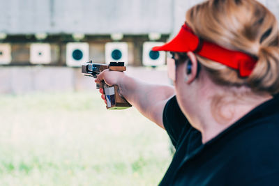 Close-up of woman shooting with pistol at target