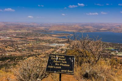 Information sign on landscape against sky