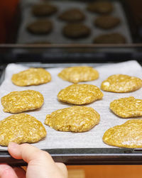 Cropped hand holding cookies on table