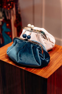 Blue and white velvet clutches on a wooden stand. fashion details, women's accessories