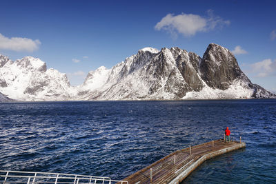Scenic view of snowcapped mountains by sea against sky
