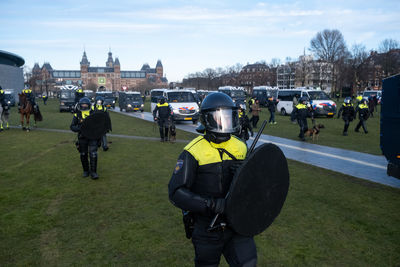 Rear view of people in city against sky