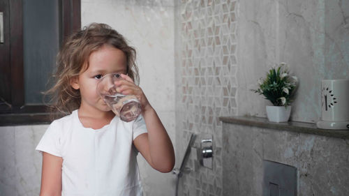 Girl drinking water in bathroom