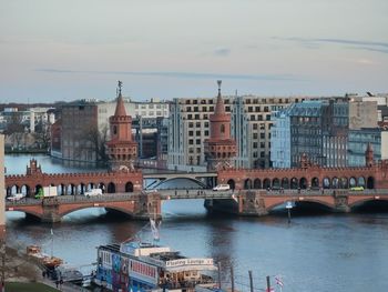 Bridge over river in city against sky