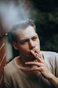 Portrait of young man smoking outdoors