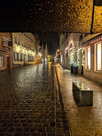 Illuminated alley amidst buildings in city at night