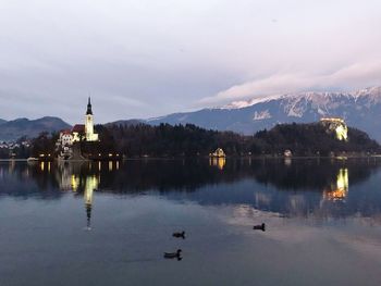 Scenic view of lake and buildings against sky