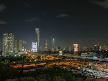 Illuminated cityscape against sky at night