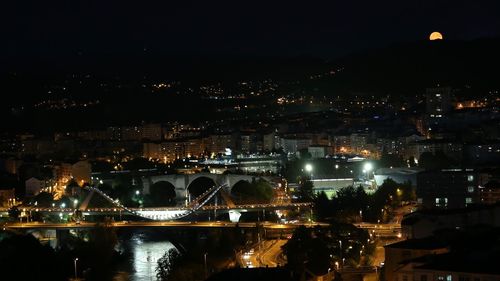 Illuminated cityscape against sky at night