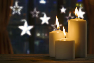 Close-up of illuminated candles on table during christmas 