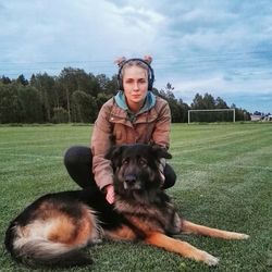 Dog standing on field against cloudy sky