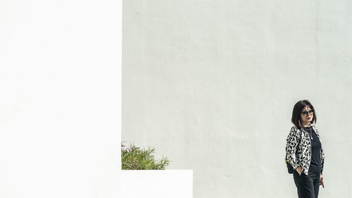 Portrait of woman standing against wall