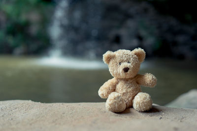 Close-up of stuffed toy on retaining wall