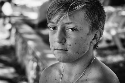 Close-up portrait of boy with sand on face