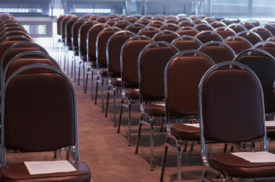 Empty chairs and tables in row