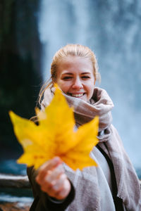 Portrait of a smiling woman holding yellow outdoors