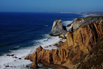 Scenic view of sea with rocks in background