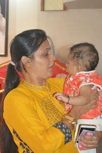 Mother and daughter while standing on floor