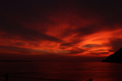 Scenic view of sea against dramatic sky during sunset