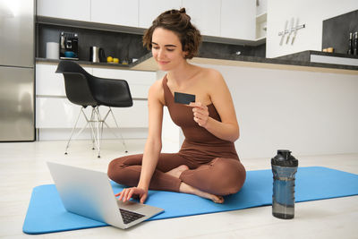 Side view of young woman exercising in gym