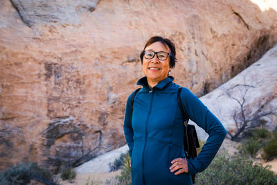 Portrait of smiling senior asian woman hiking in the desert landscape