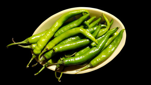 Close-up of green chili pepper against black background