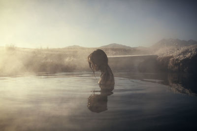 Side view of woman swimming at mammoth lake hot springs
