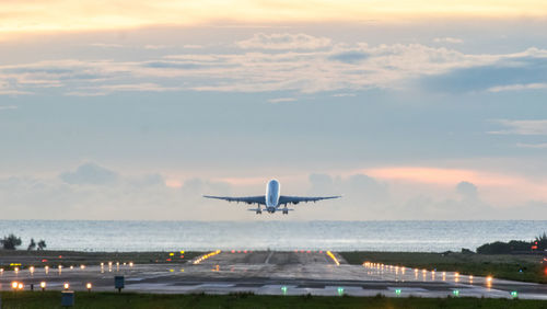 Airplane flying over sea against sky