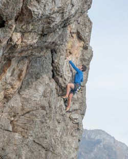 Low angle view of man climbing on rock