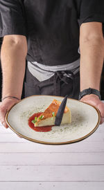 Chef presenting plate of new york cheesecake or classic cheesecake with fresh, appetizing healthy.