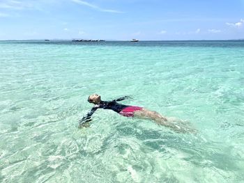 Man swimming in sea against sky