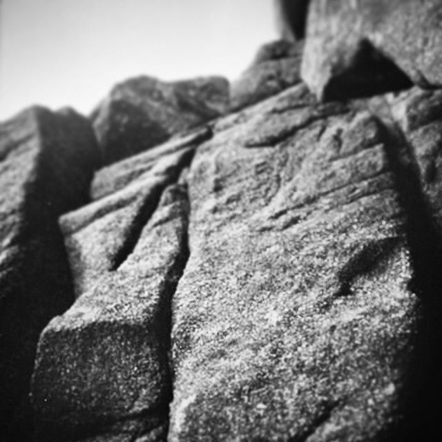 textured, close-up, rough, focus on foreground, selective focus, stone material, no people, day, rock - object, outdoors, old, low angle view, stone, weathered, detail, nature, pattern, sunlight, sky, tranquility