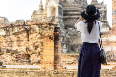 Asian female tourists taking pictures at wat phra si sanphet, phra nakhon si ayutthaya, thailand.