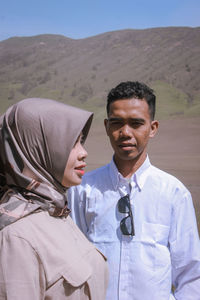 Portrait of man and woman standing on mountain