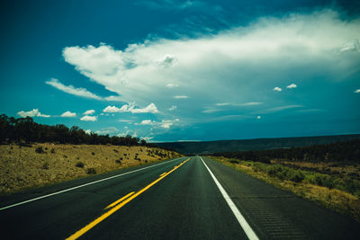 Empty road along countryside landscape
