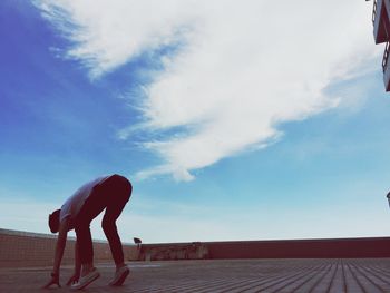 Side view of man standing against sky