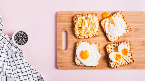 Eggs prepared to different recipes on toast on a wooden board top view web banner